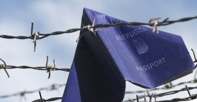 A flag behind barbed wire.