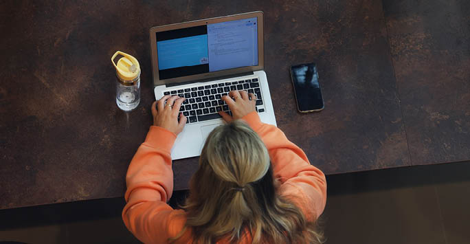 Girl typing on a laptop.