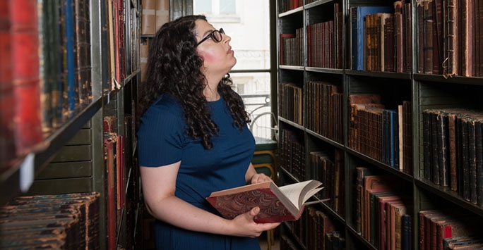 A girl looking at books in a library,