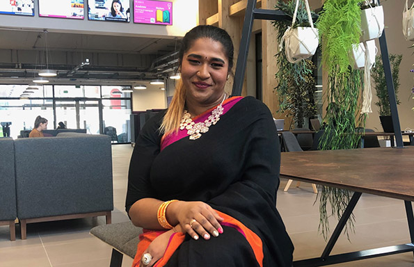 Laxmi sitting in the foyer of the School of Law and Social Justice