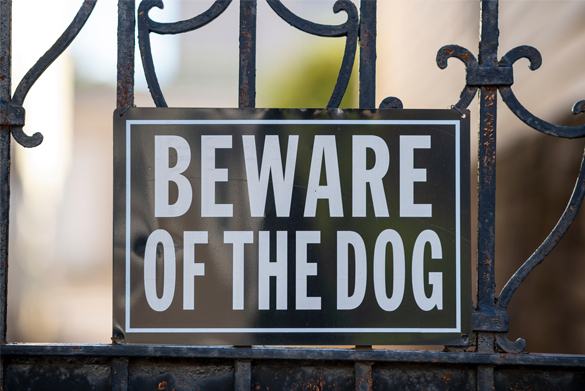 A metal sign attached to a fence that reads 