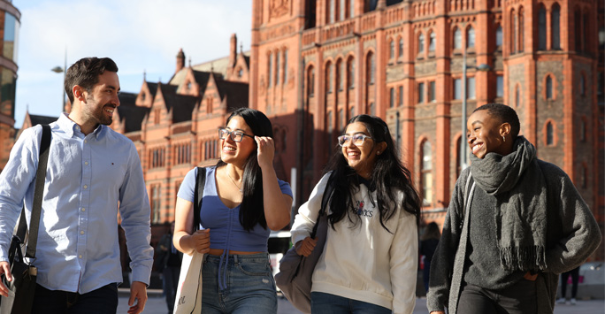 Four students walking together on campus.