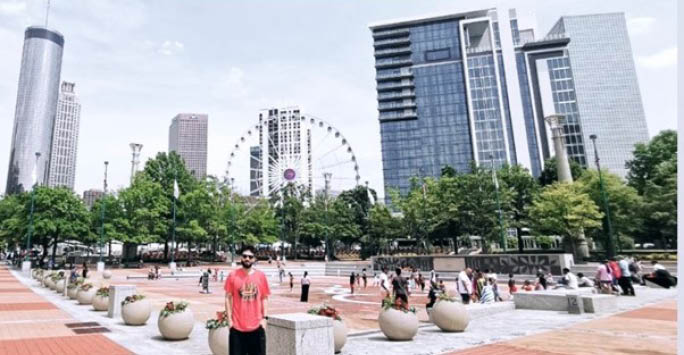 A photo of Ammar Zafar in Georgia in front of the wheel.