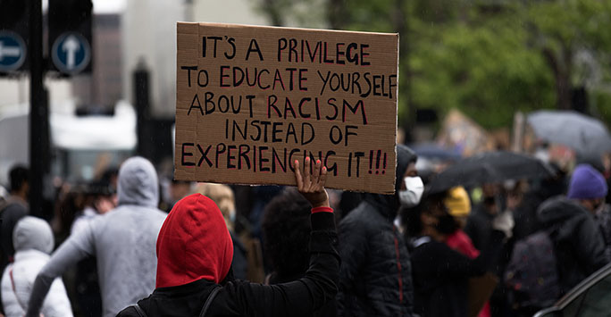 Black Lives Matter protest placard that reads 'It's a privilege to educate yourself about racism instead of experiencing it!!!' 