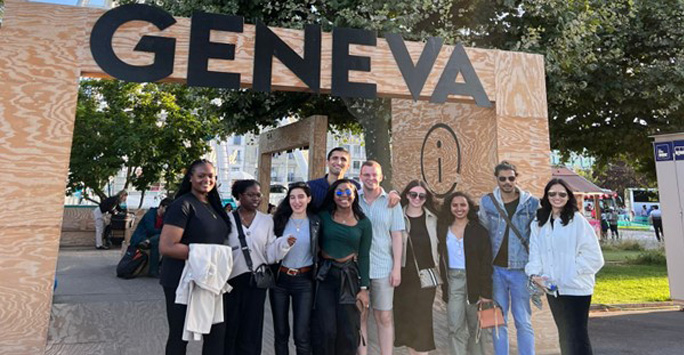 The group of students in front of a sign that says Geneva