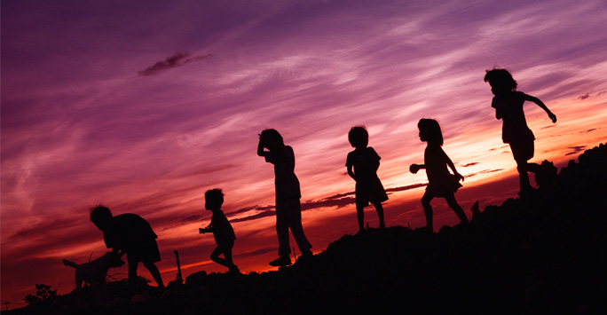 Children walking down a hill at dusk