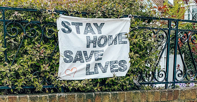 World Population Day Stephanie Martin 'Stay Home Save Lives' banner on a hedge photo