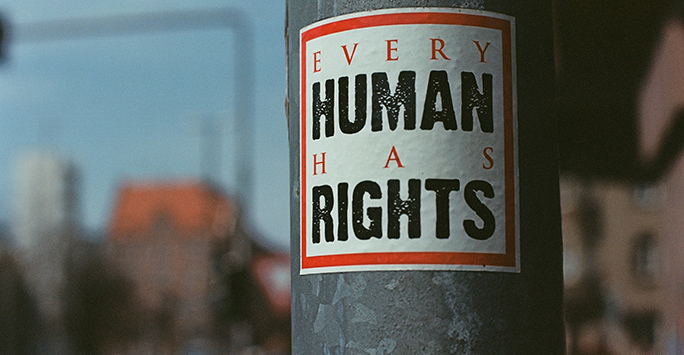 Sticker on lampost that reads 'every human has rights' 