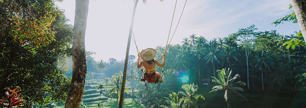 Woman on a swing overlooking the rice fields in Ubud, Bali