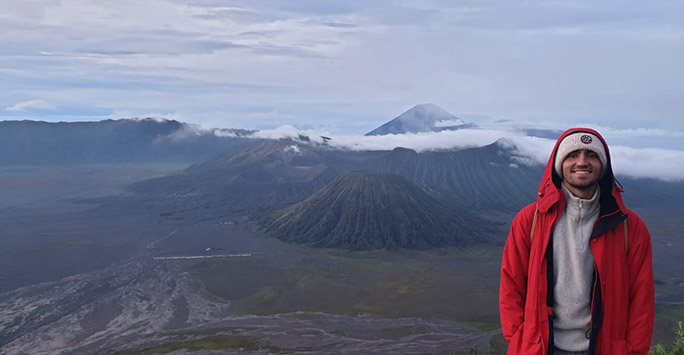 Student stood at top of a mountain