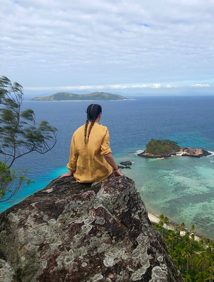 Student on mountain perch looking over islands