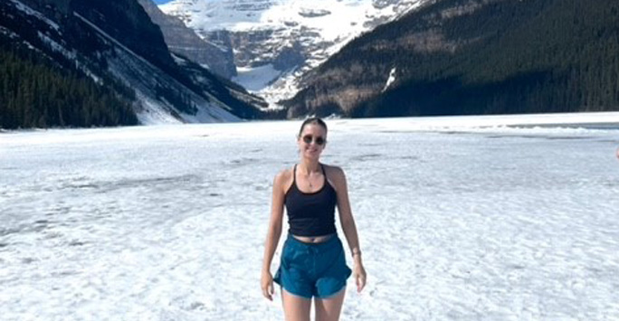 Heidi stood on a snowy landscape surrounded by mountains