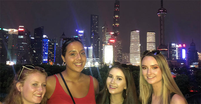 Students in front of city skyline at night