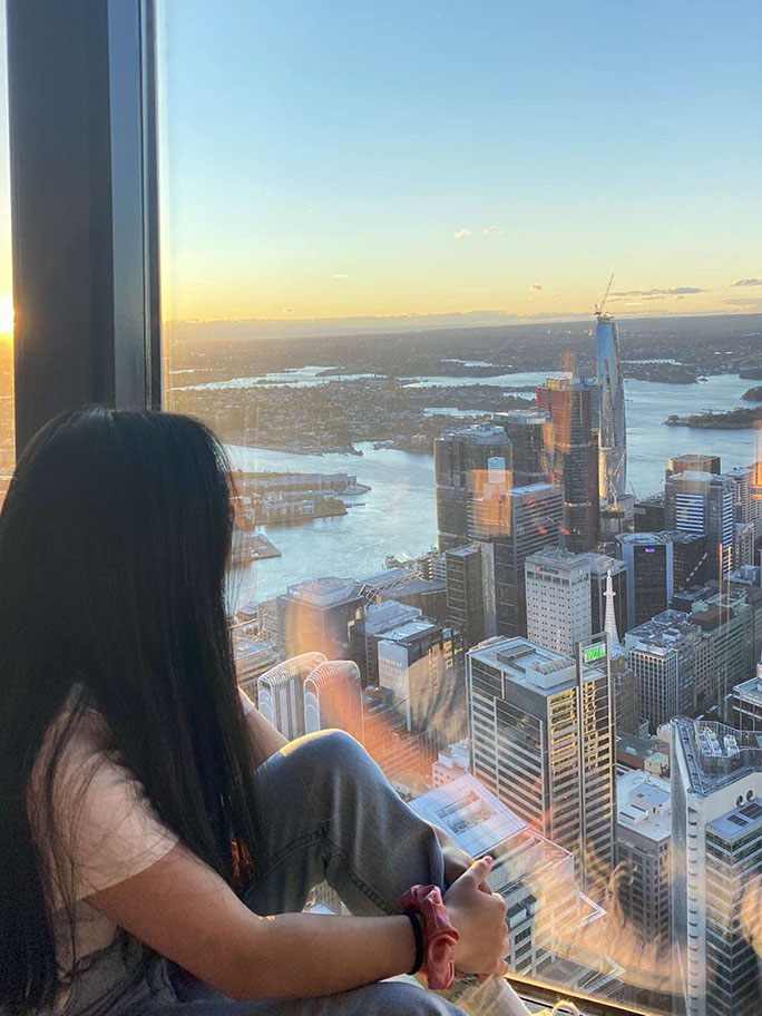 Student looking out the window onto Sydney skyline