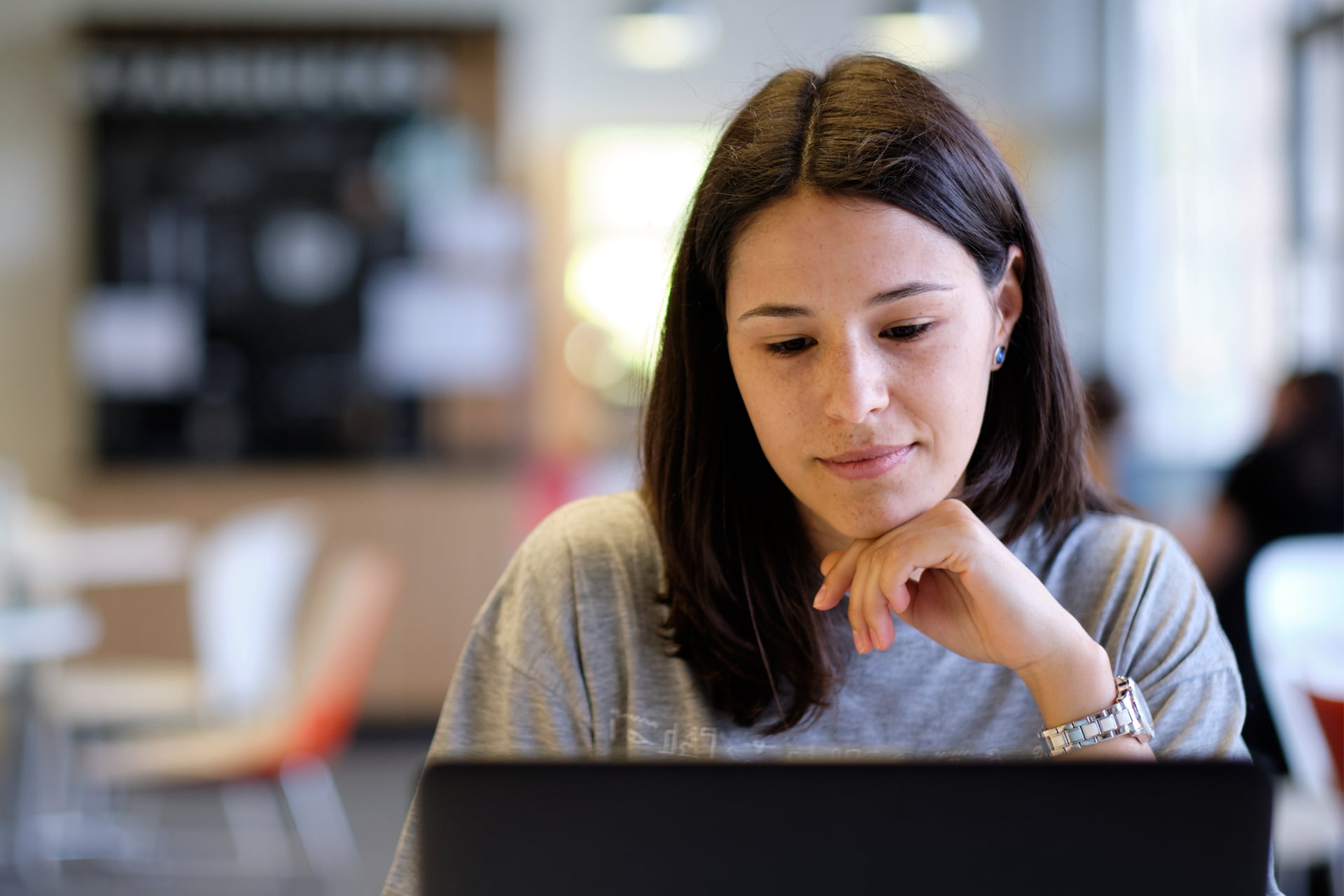 A students sits working on a laptop.