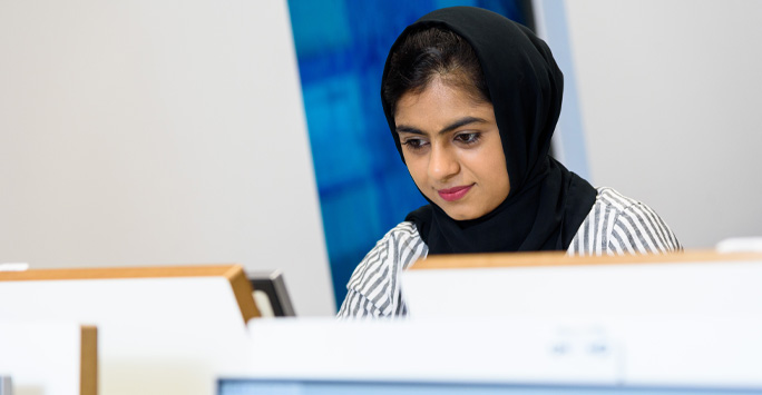 A student using a computer in a on-campus computer suite.