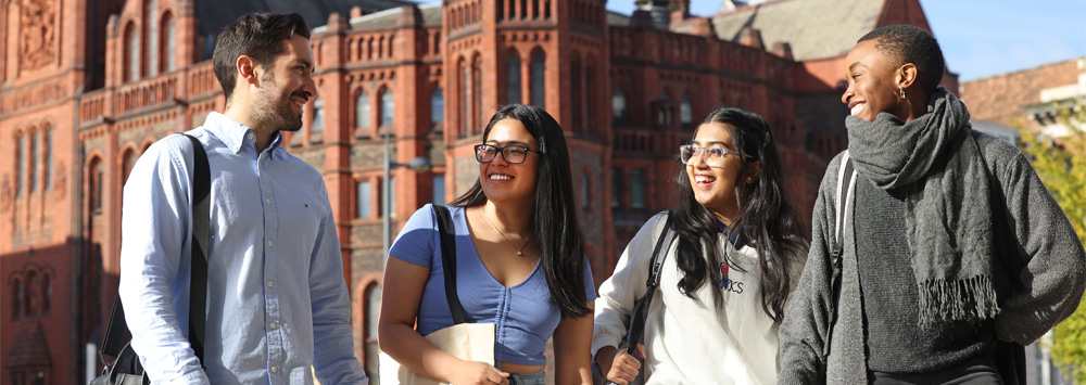 Four students walking together on-campus.