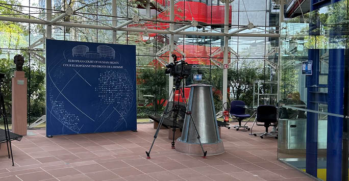 European Court of Human Rights Sign with Camera in front.