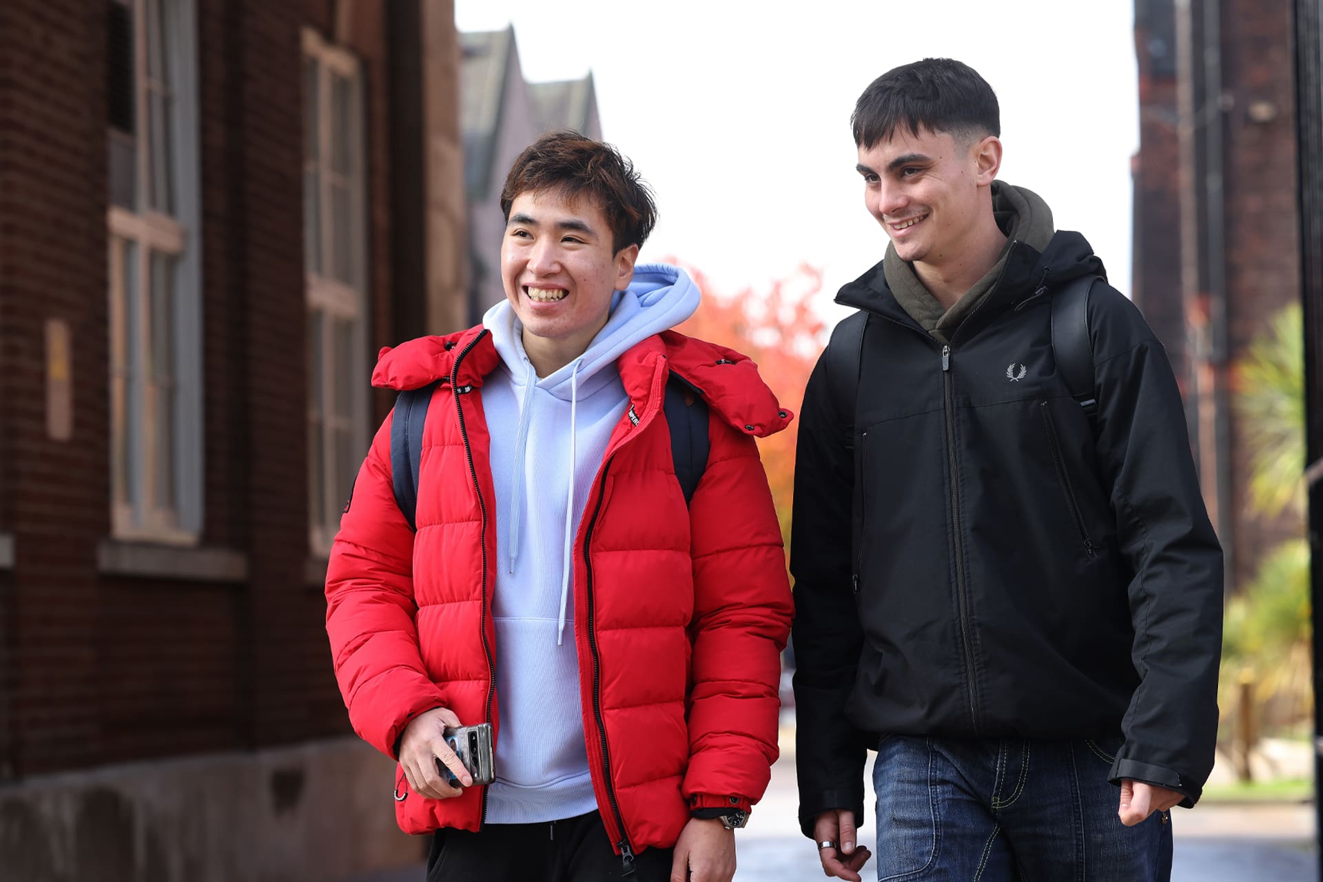 Two students walk together through campus.