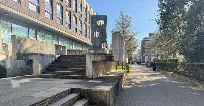 Barbara Hepworth sculpture next to the Sydney Jones Library. An absract obelisk with two holes.