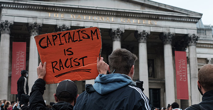 Black Lives Matter protest in London - photo of a 'Capitalism is Racist' placard by Ehimetalor Akhere Unuabona