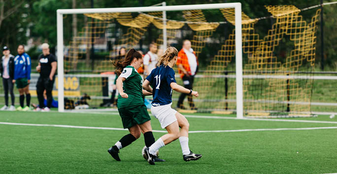 Two girls playing football