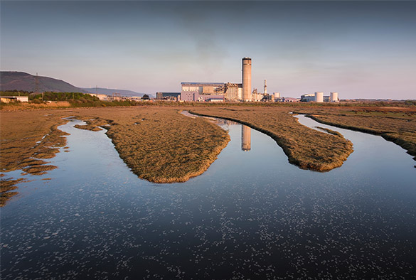 Baglan Bay Power Station reflected in the water, Port Talbot. Photo by Leighton Collins via Shutterstock
