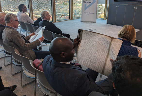 A delegate examines a copy of the original case papers from Solomons v. Ross