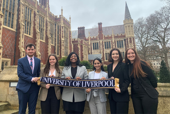 A group of students stood outside Lincolns Inn. They are holding a University of Liverpool scarf