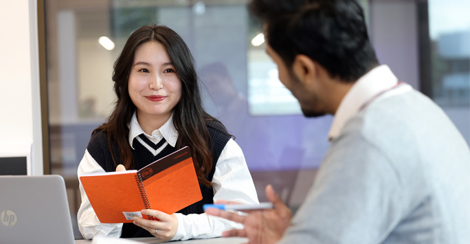 Two students in a seminar talking to eachother