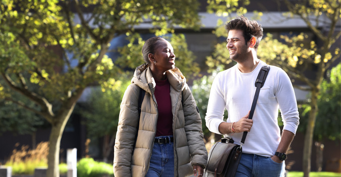 Two students walking through campus together