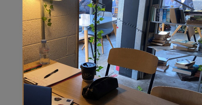 Laptop and stationary on a table in a coffee shop