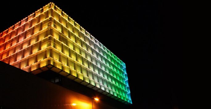Building lit up in pride flag colours
