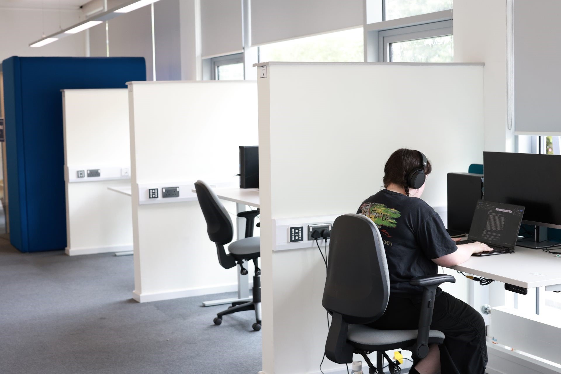 A student sat at a desk working on a laptop in the accessible study room at the Sydney Jones Library