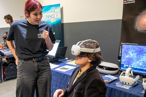 A person explaining something to another person who is wearing a VR headset.