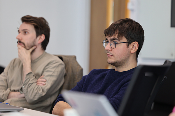 Two students sitting on a table.