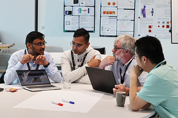 A group of people sitting on a table and discussing something.