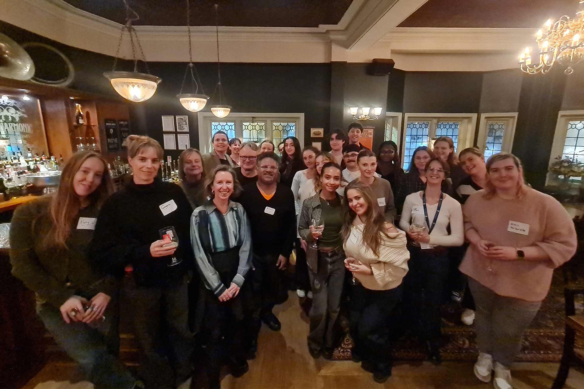 A group of people standing inside smiling.