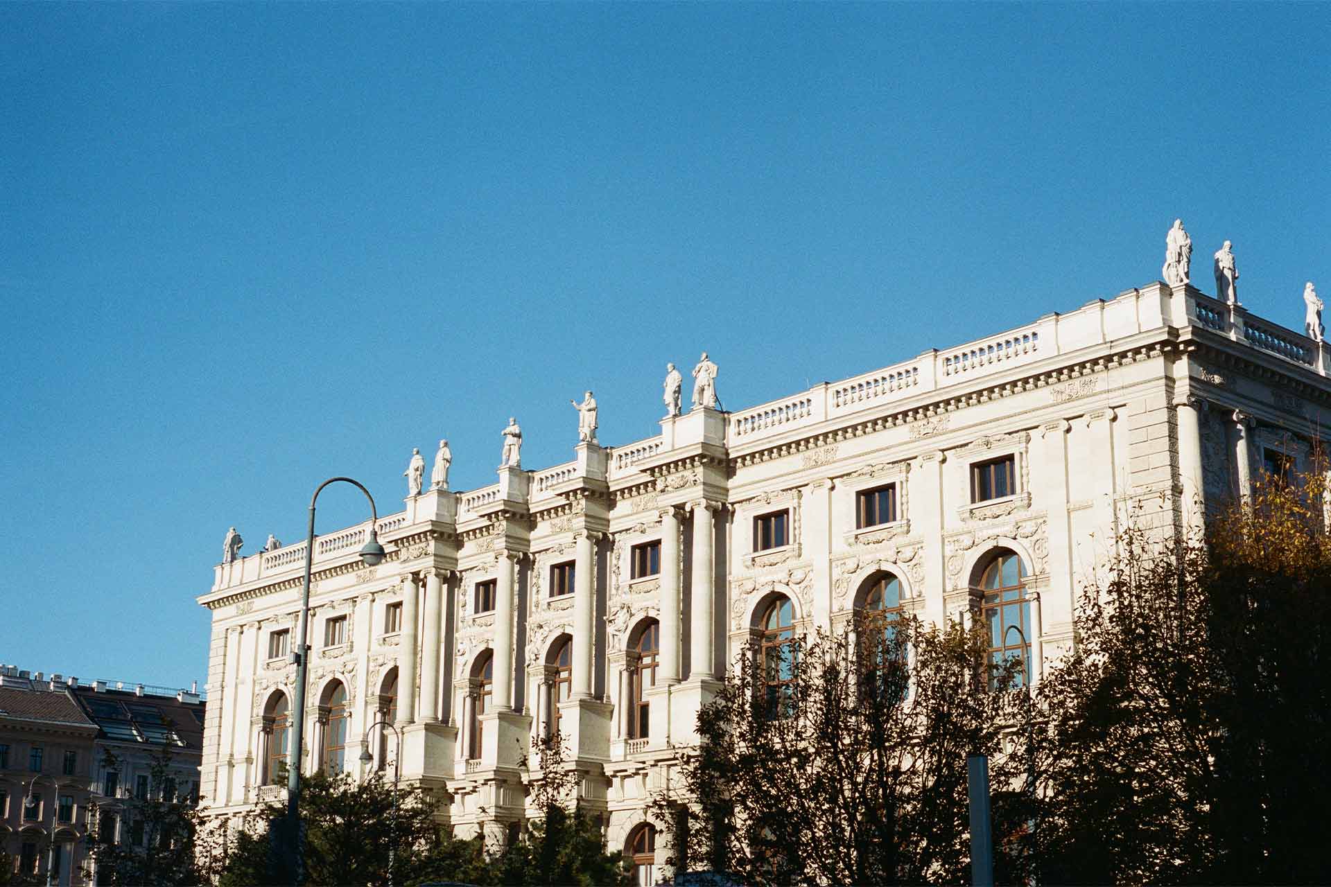 A clear blue sky with grand parliamentary building with light coloured stone.