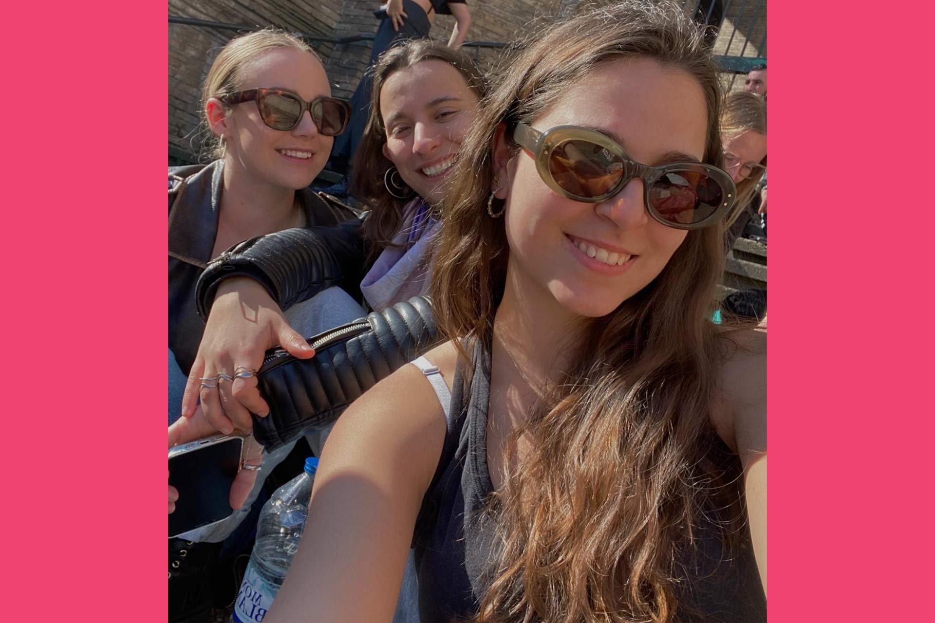 A selfie of three young women two wearing sunglasses and smiling.