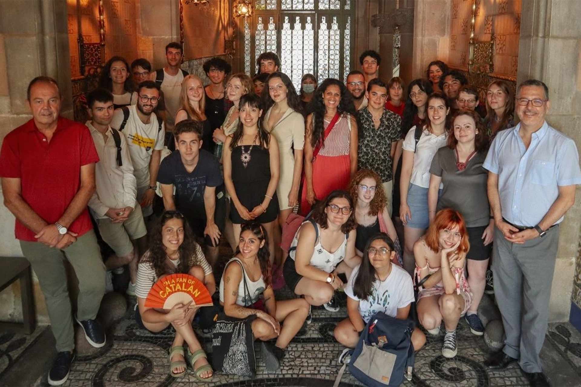 A large group of people gathered outside a building standing smiling for the photo.