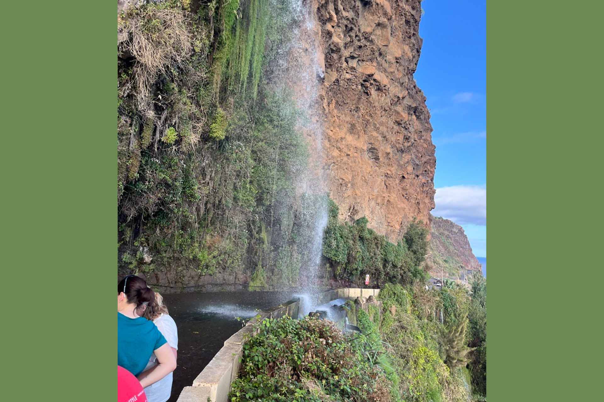 A waterfall on a tall sandy cliff.
