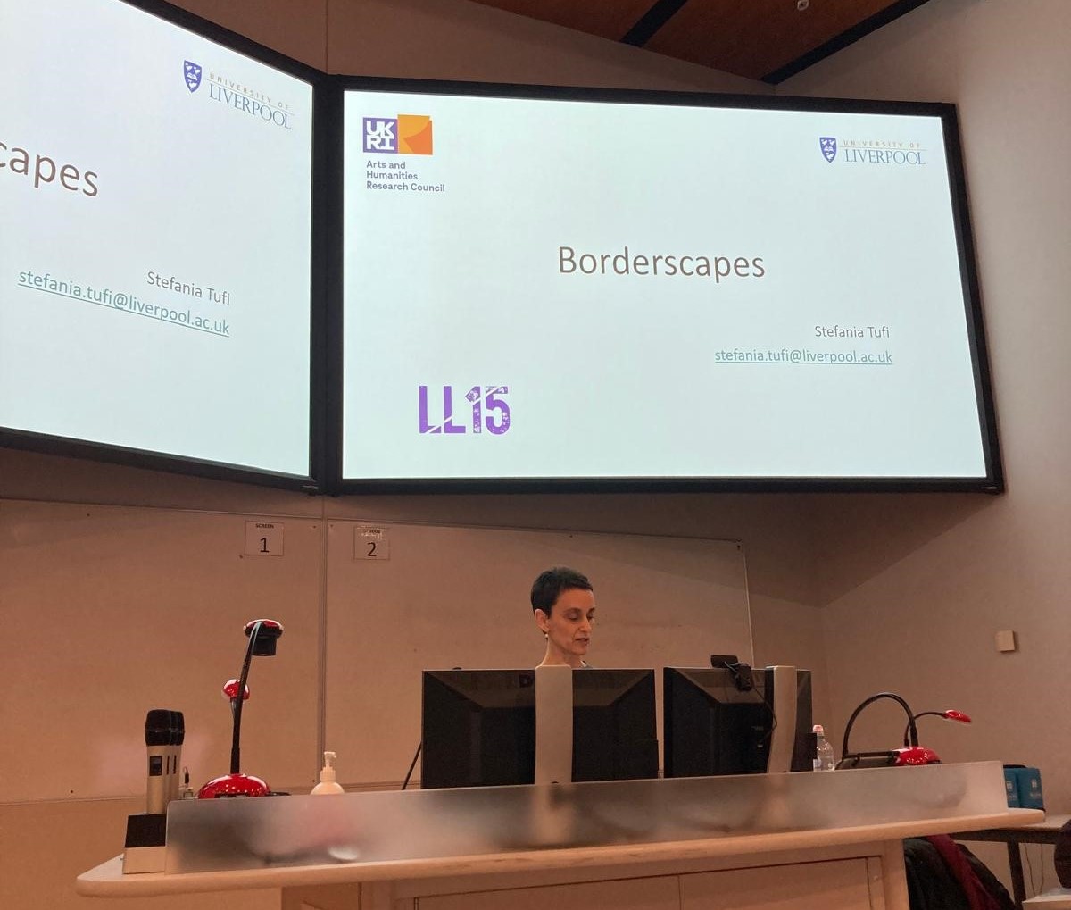 Prof. Stefania Tufi standing infront of a screen delivering the keynote