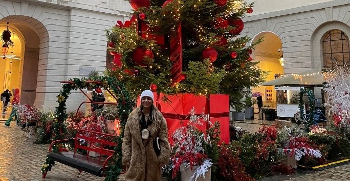 Image of sarah in front of a Christmas tree.