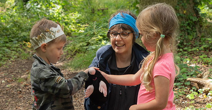 Two children examine a toy mole while on a bug hunt during a school visit at Ness Botanic Gardens.
