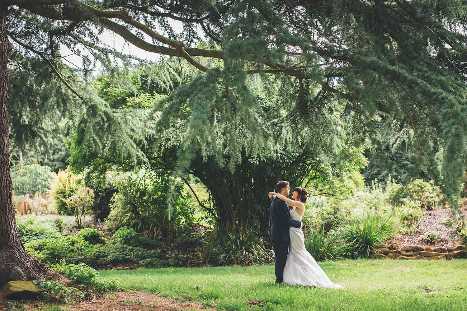 A couple embrace, surrounded by the stunning greenery of Ness, as they celebrate their wedding.