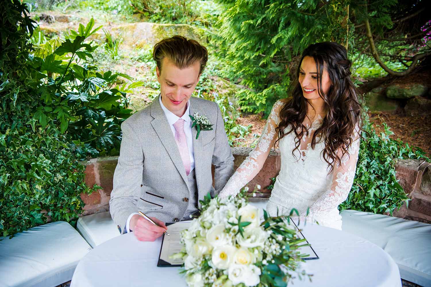 A couple sign the wedding register after their ceremony in the Rock Garden.