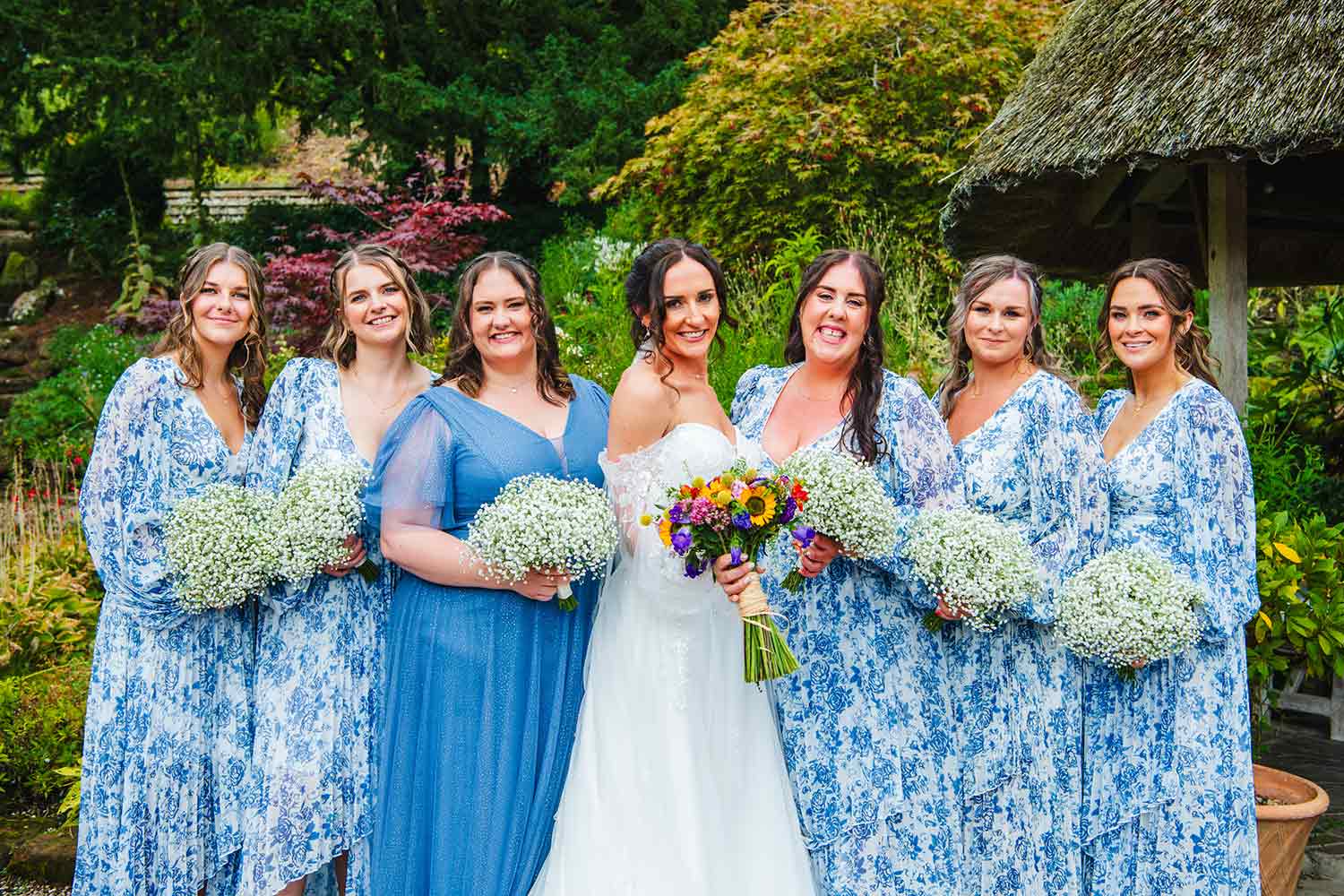 A group of wedding guests chat near the thatched gazebo in the Rock Garden.