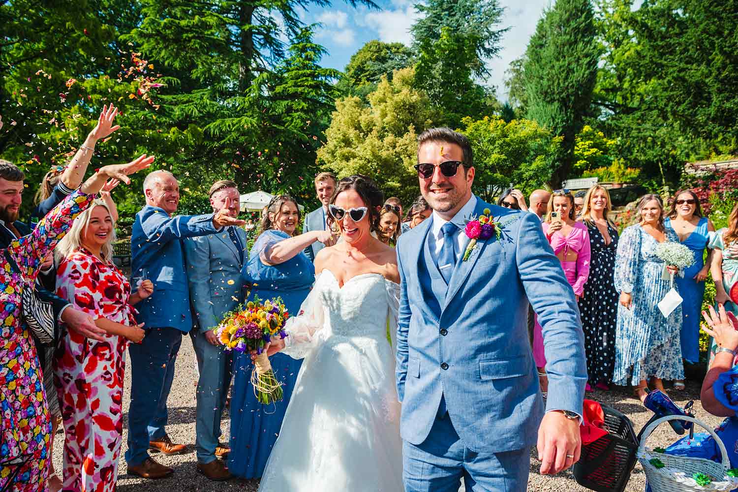 A couple depart the Rock Garden after their wedding, cheered by family and friends.
