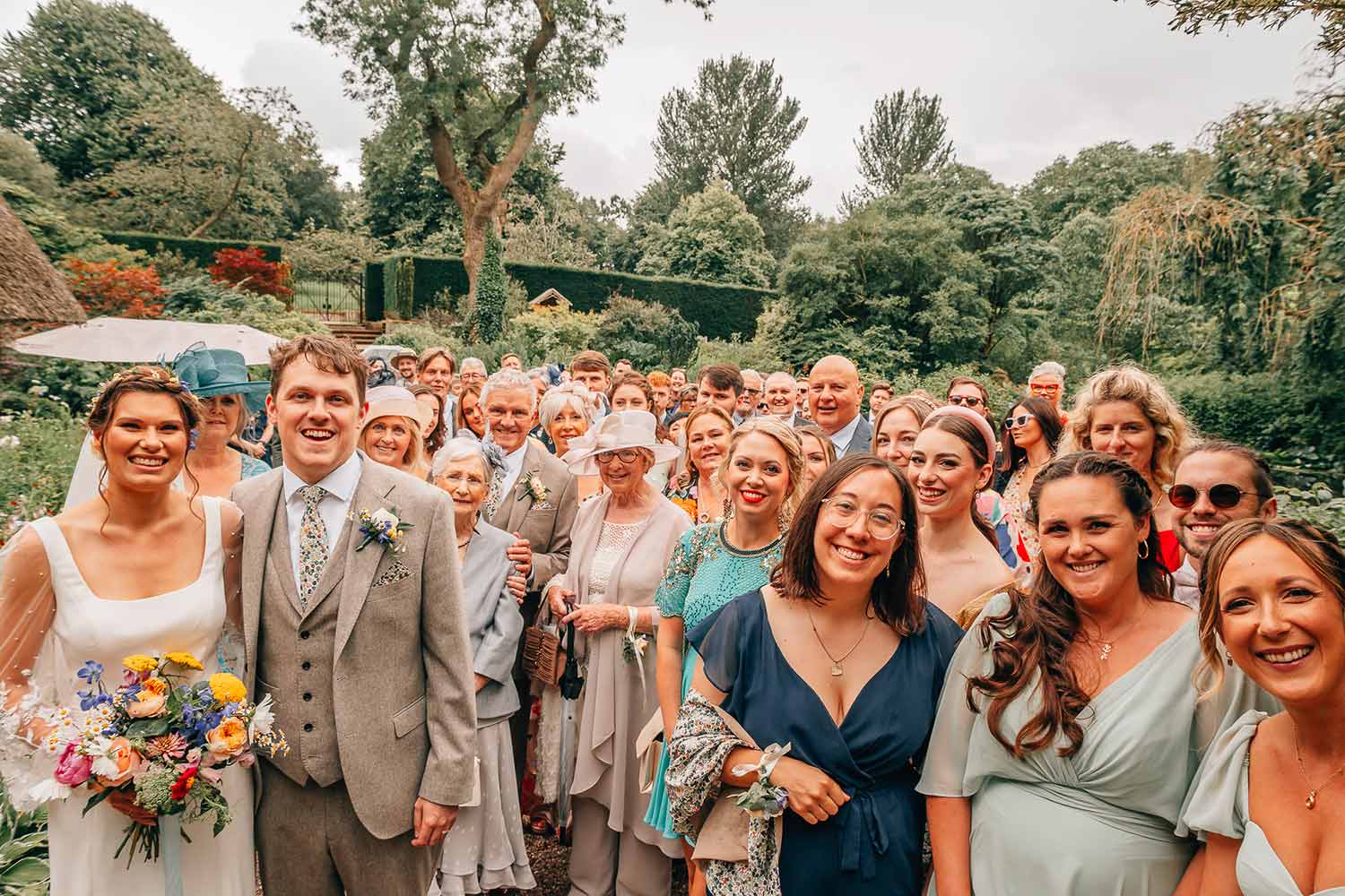 A couple and their wedding guests pose for a group photo in the Rock Garden.